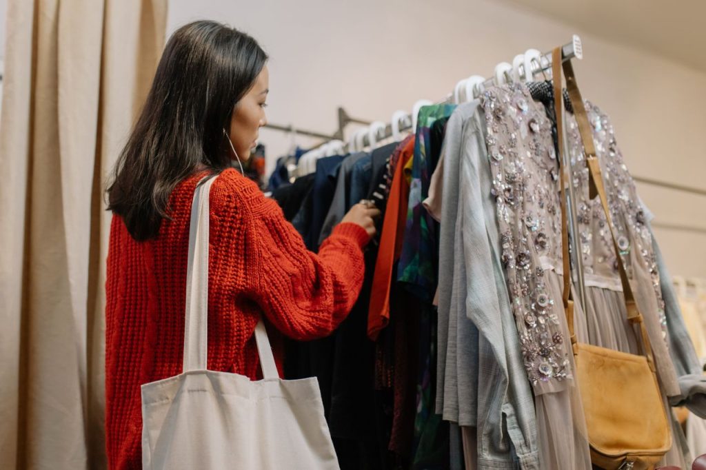 Crafting Captivating Headlines: Your awesome post title goes here A woman browses a clothing rack in a cozy thrift shop, selecting garments.